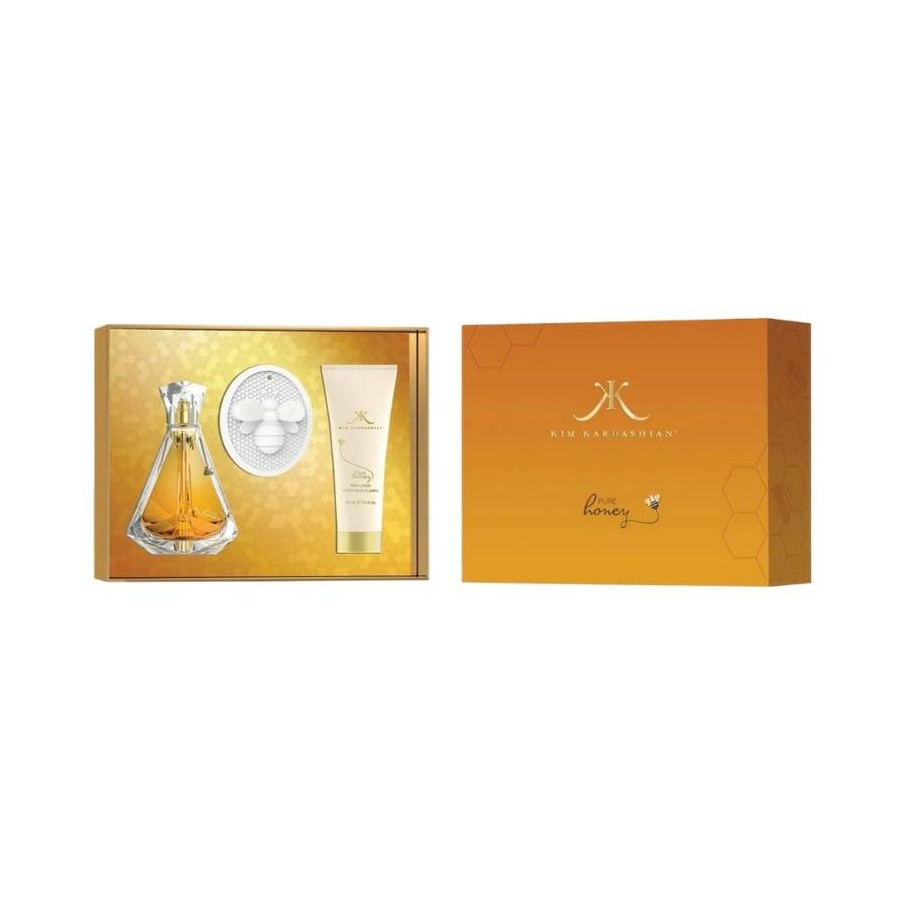 Kim Kardashian 'Praise' fragrance gift set, featuring a clear glass perfume bottle with amber liquid, a round white body wash container, and a white lotion tube, displayed next to its orange and gold packaging box on a white background.